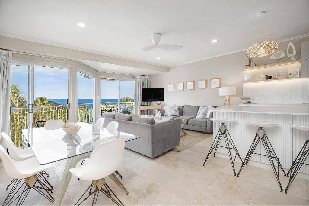 a living room with a table and a fireplace at Unit 9 Fantastic Holiday Apartment in Sunshine Beach Stunning Views Opposite Beach Access in Sunshine Beach