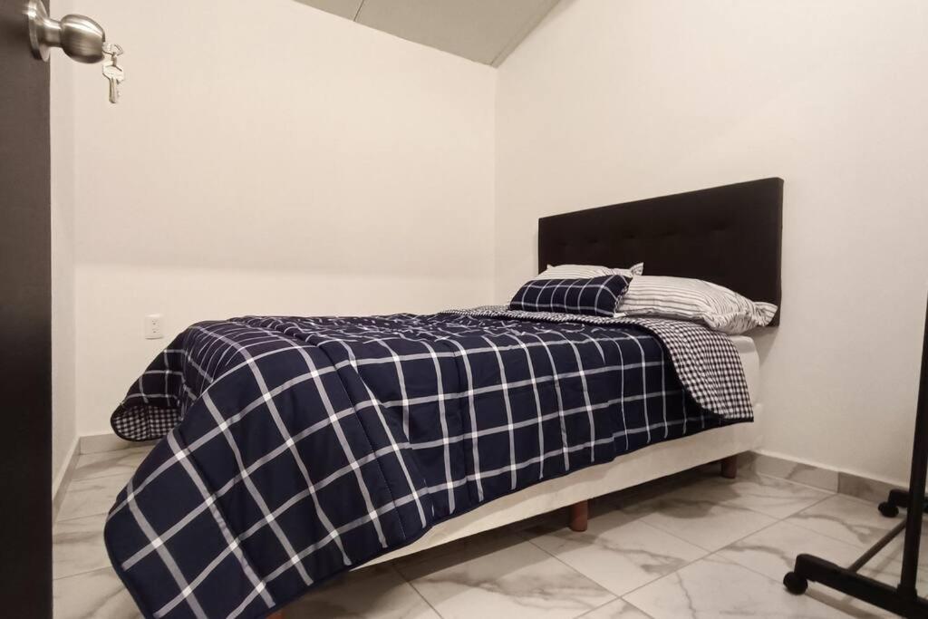 a bedroom with a bed with a black and white blanket at Departamento Excelente ubicación Depto C in Orizaba