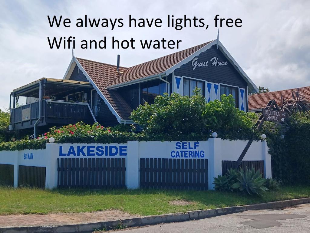 a house with the words we always have lights free wifi and hot water at Lakeside Accommodation in Knysna