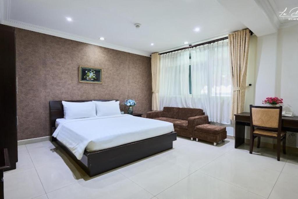 a bedroom with a bed and a desk and a chair at Bonita Boutique Hotel in Ho Chi Minh City