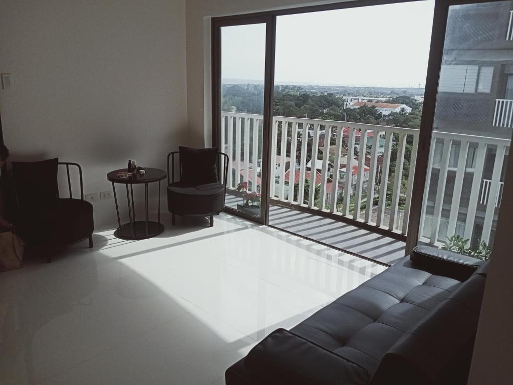 a living room with a couch and a large window at Condotel 810 in Iloilo City