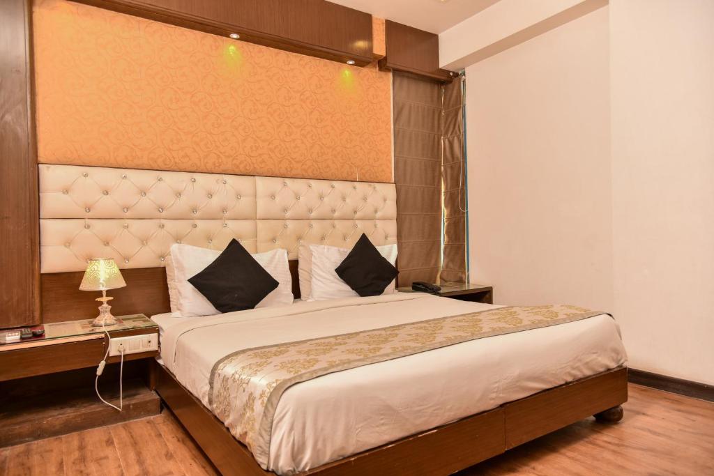 Hotel Lyf Corporate Suites - Near IGI Airport في نيودلهي: غرفة نوم بسرير كبير مع اللوح الأمامي