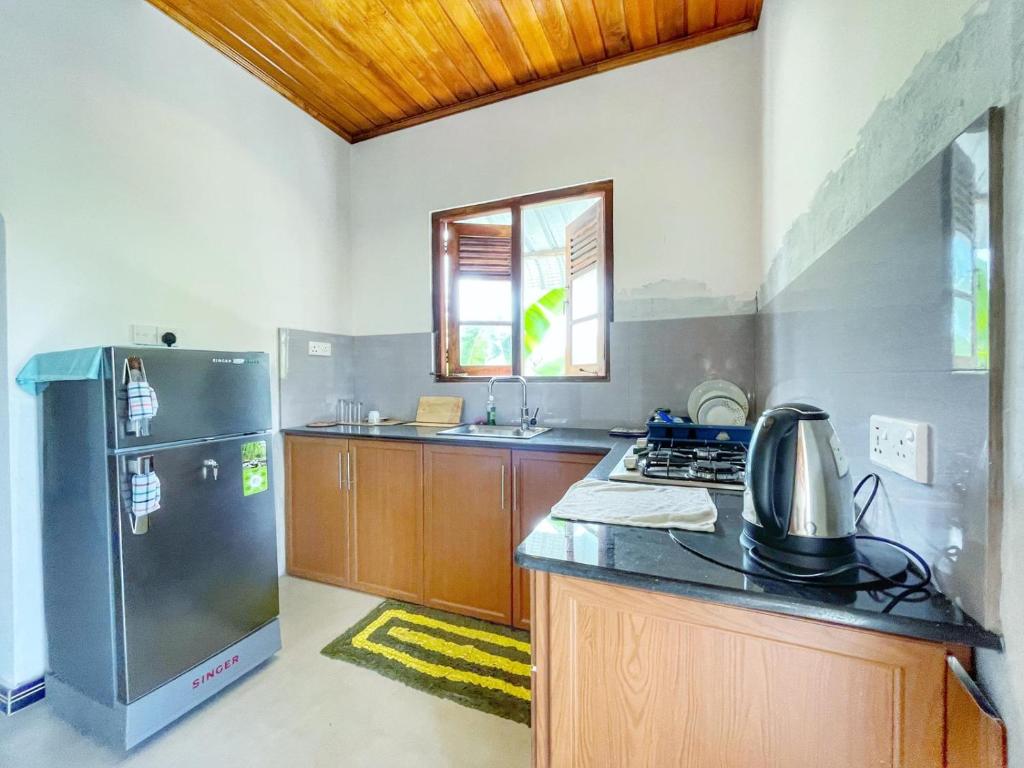 a kitchen with a refrigerator and a stove top oven at The beach gate villa in Beruwala