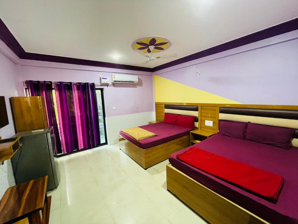 1 dormitorio con 2 camas y TV. en Susegado by js apartment en Calangute