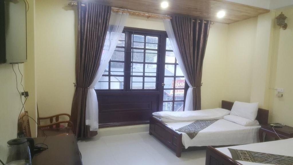 a bedroom with two beds and a window at Sapa Hostel - 679 Đường Điện Biên Phủ, TT. Sa Pa -by BayLuxury in Sa Pa