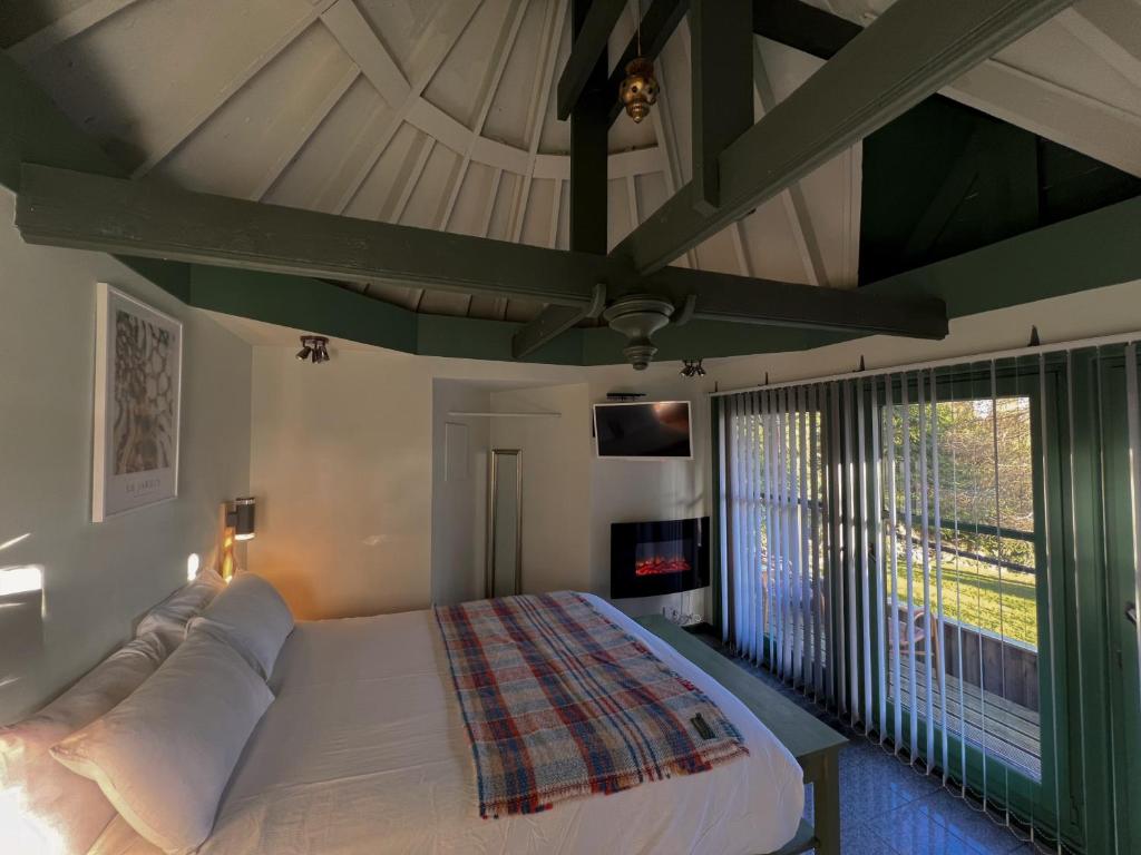 a bedroom with a large bed and a large window at Ivybank Villa in Rothesay