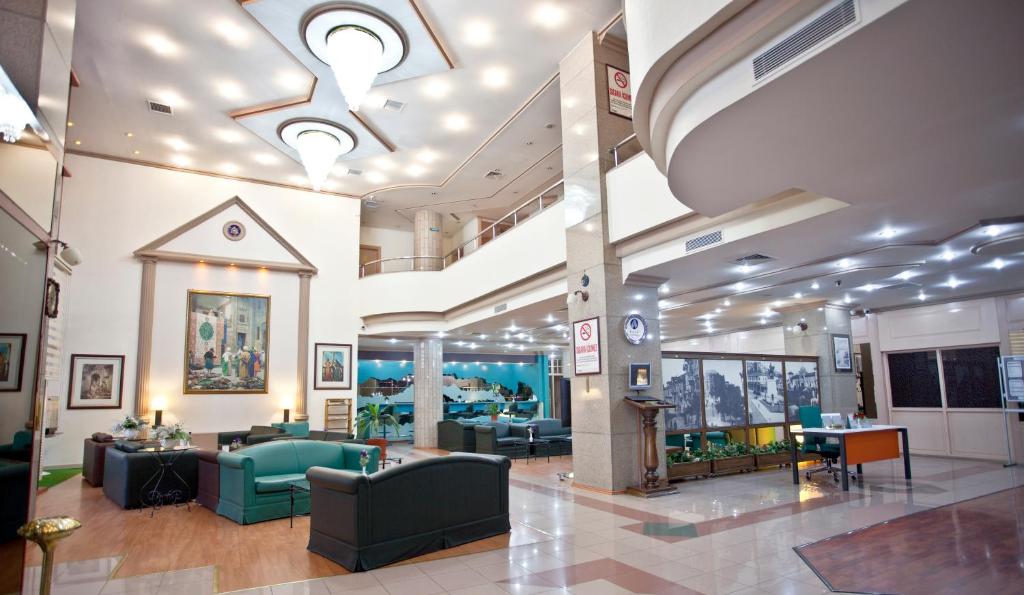 a lobby with couches and chairs in a building at Sergah Hotel in Ankara