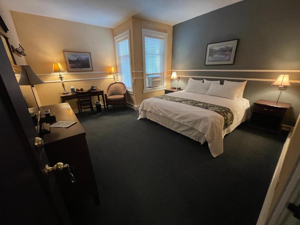 Pokój hotelowy z łóżkiem i biurkiem w obiekcie Kalispell Grand Hotel w mieście Kalispell