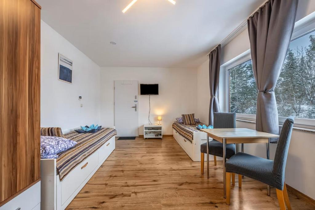 een slaapkamer met bedden, een tafel en een bureau bij FeWo PeDa Nord in Norderstedt