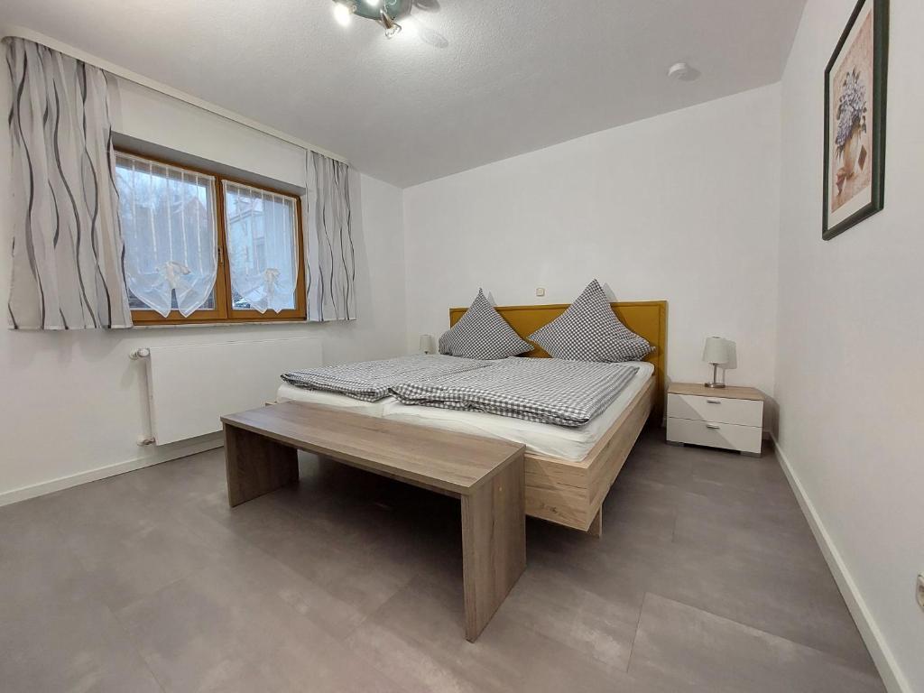 ein Schlafzimmer mit einem Bett und einem Tisch darin in der Unterkunft Ferienwohnung Talgrund "Im Grünen" in Frammersbach