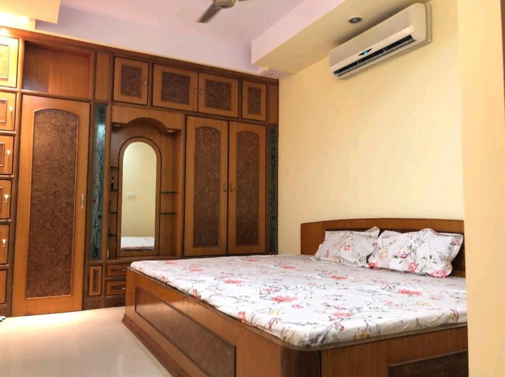 Schlafzimmer mit einem Bett mit einem Kopfteil aus Holz in der Unterkunft The happy shack in Jaipur