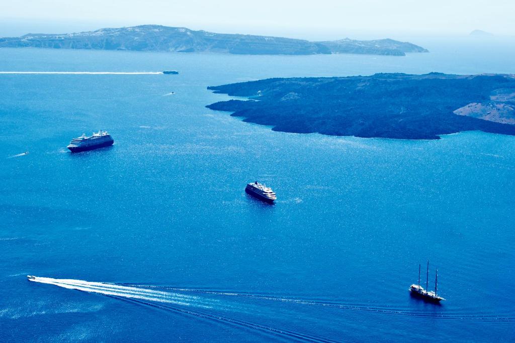 a group of boats in a large body of water at Aeolos Art & Eco Suites Adults Only in Imerovigli