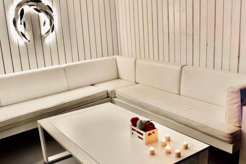a living room with a white couch and a table at Aeolos Art & Eco Suites Adults Only in Imerovigli