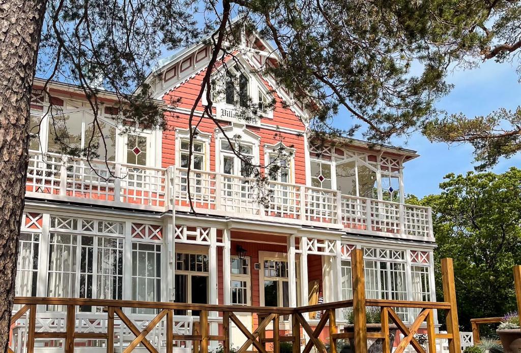 ein rotes und weißes Haus mit einem weißen Balkon in der Unterkunft Villa Maija 3 Westside in Hanko