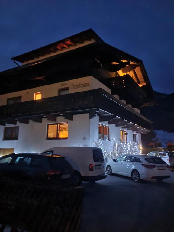 ein Gebäude mit Autos auf einem Parkplatz mit Weihnachtsbeleuchtung in der Unterkunft Haus Bergkranz in Lermoos