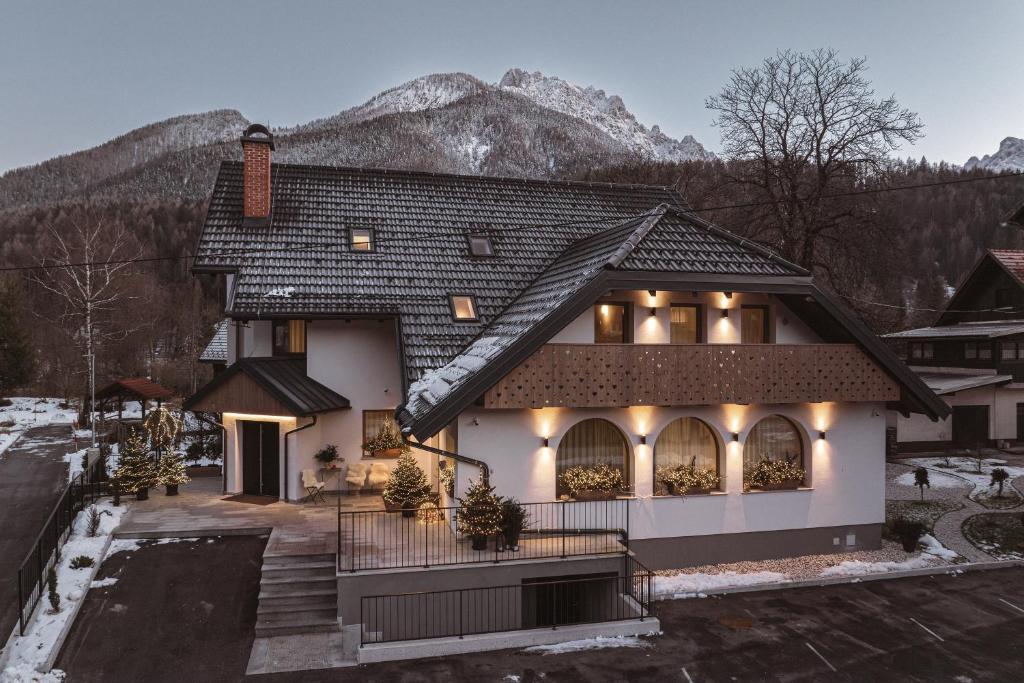 a house with a mountain in the background at Apartments and Rooms Kaja in Kranjska Gora