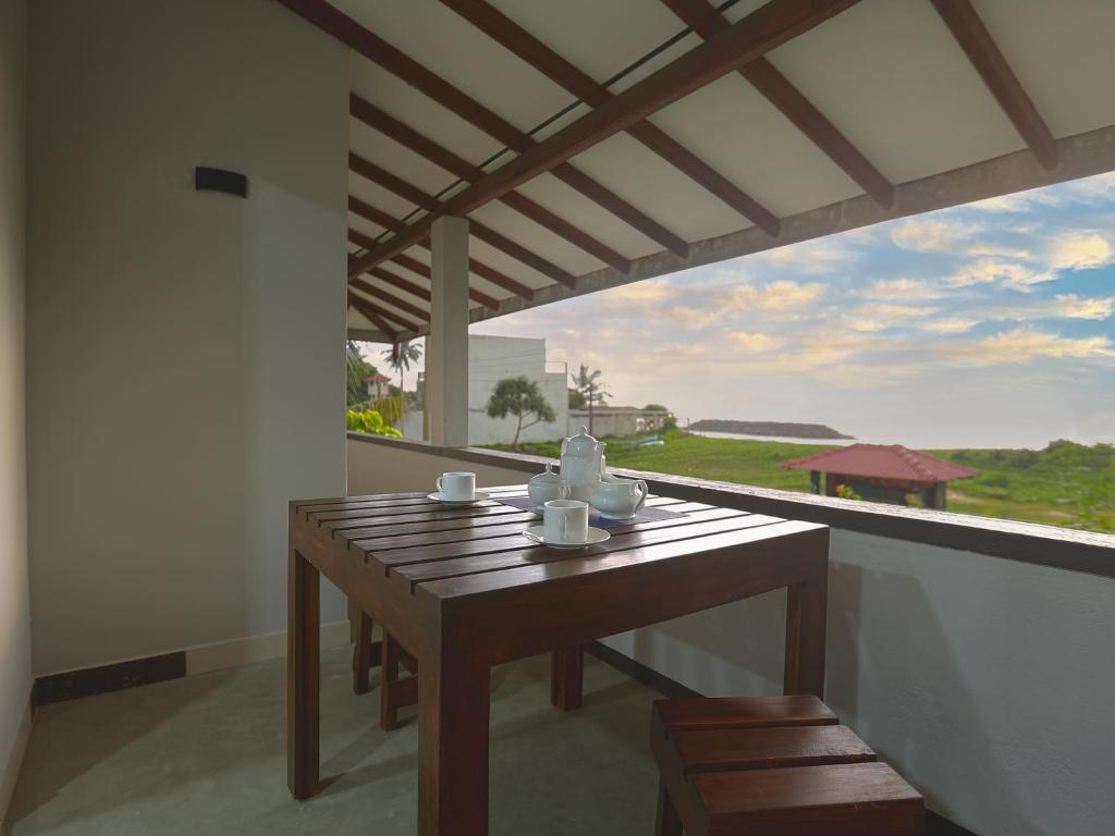 a table and chairs on a balcony with a view at Sea View Villa in Hikkaduwa