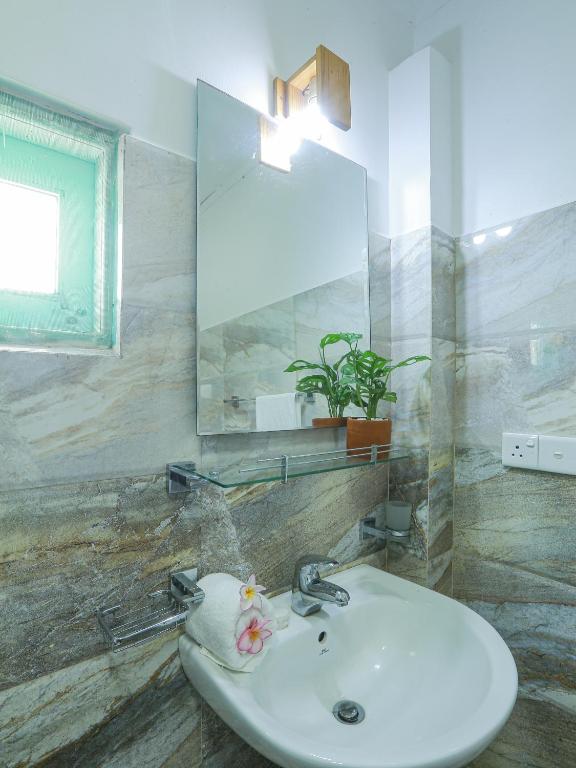 a bathroom with a sink and a mirror at Sea View Villa in Hikkaduwa