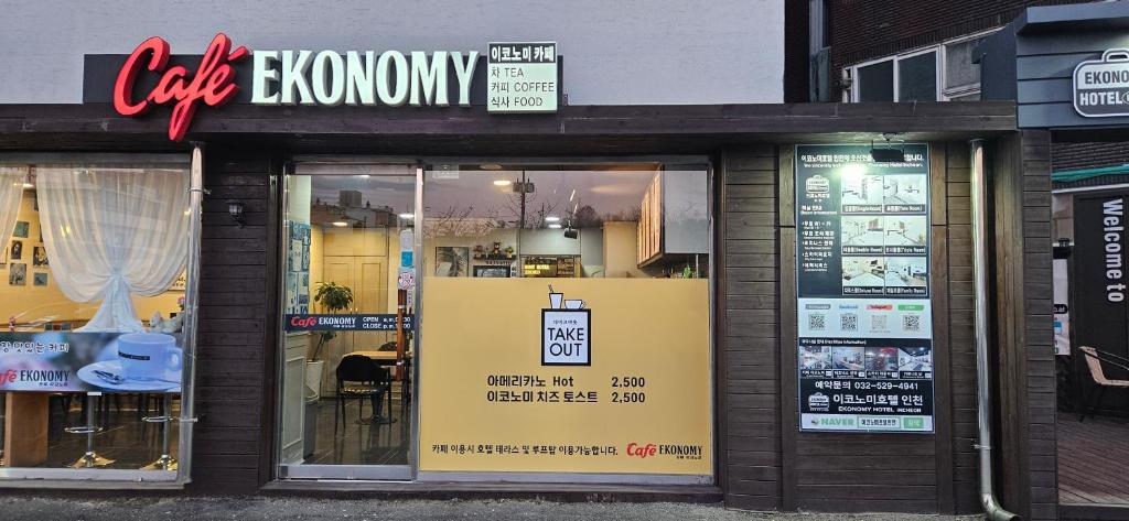 a store front with a cafe arrowory sign on the window at Ekonomy Hotel Incheon in Incheon