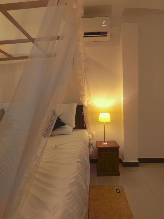 a bedroom with a white bed with a canopy at Sea View Villa in Hikkaduwa