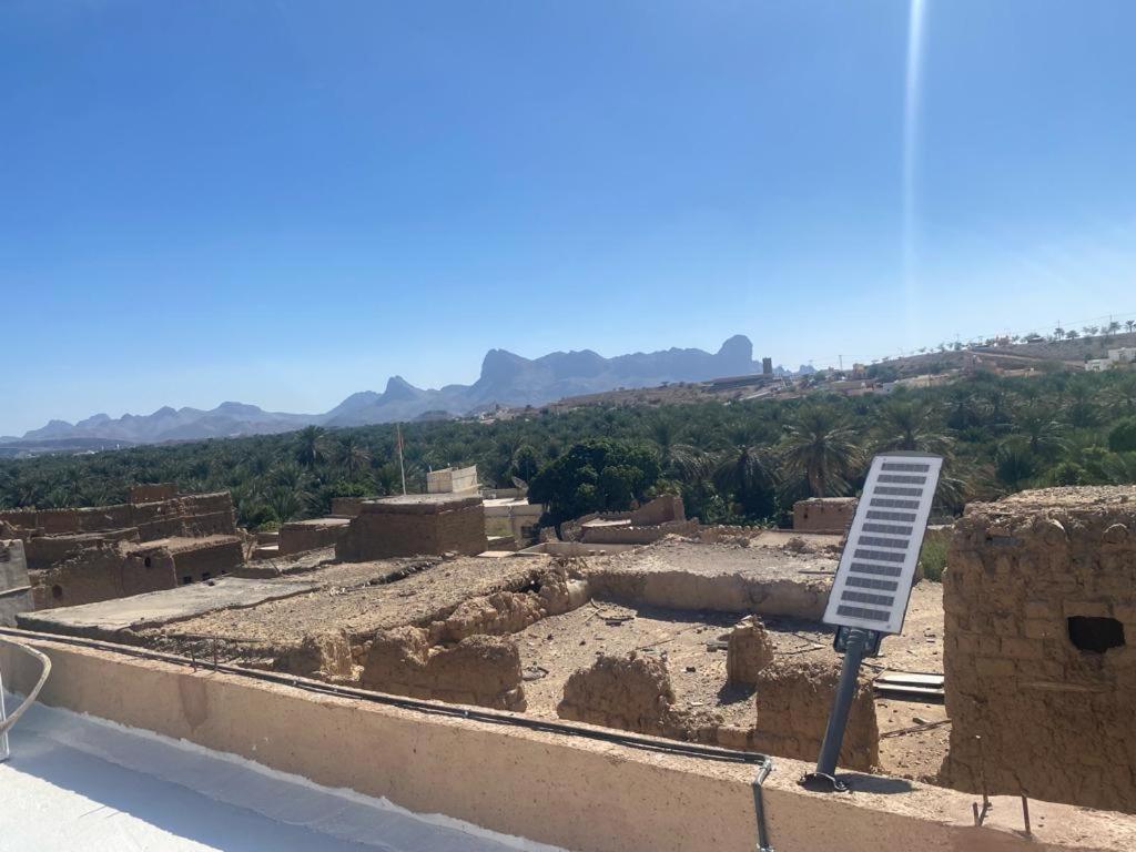 - une vue sur un bâtiment avec un panneau devant lui dans l'établissement بيت النحوي التراثي _ Bait Al Nahwai, à Al Hamra