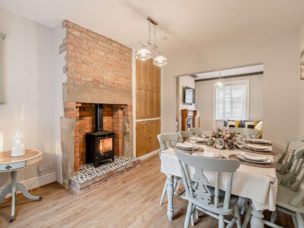 a dining room with a table and a fireplace at 4 Bed in Fleetwood 91701 in Fleetwood