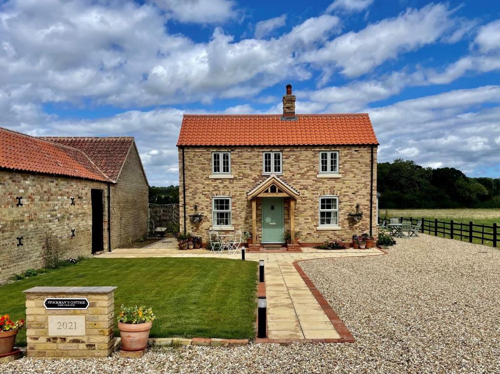 an old stone house with a green door and a yard at 2 Bed in Woodhall Spa 91957 in Kirkby on Bain