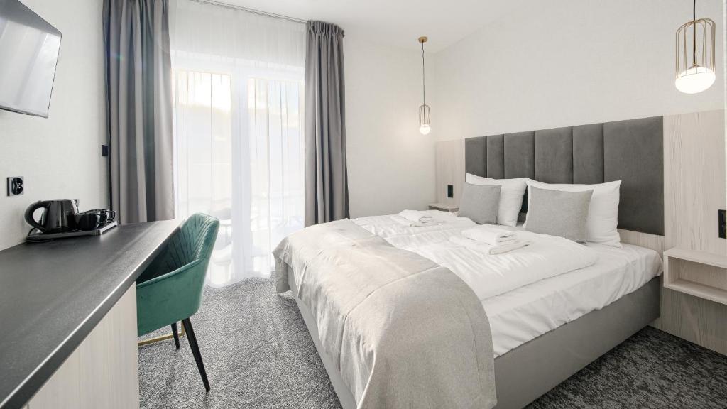 een hotelkamer met een groot bed en een bureau bij Apartamenty Sun & Snow na Spokojnej in Kołobrzeg