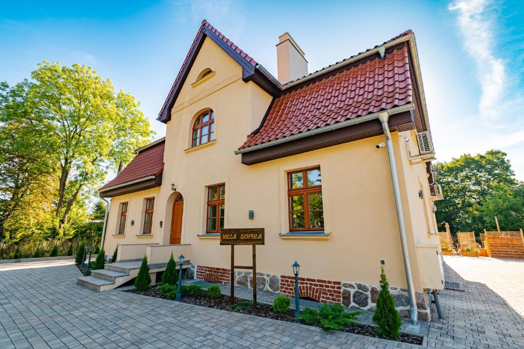 une maison avec un panneau devant elle dans l'établissement Villa Sophia, à Biskupiec