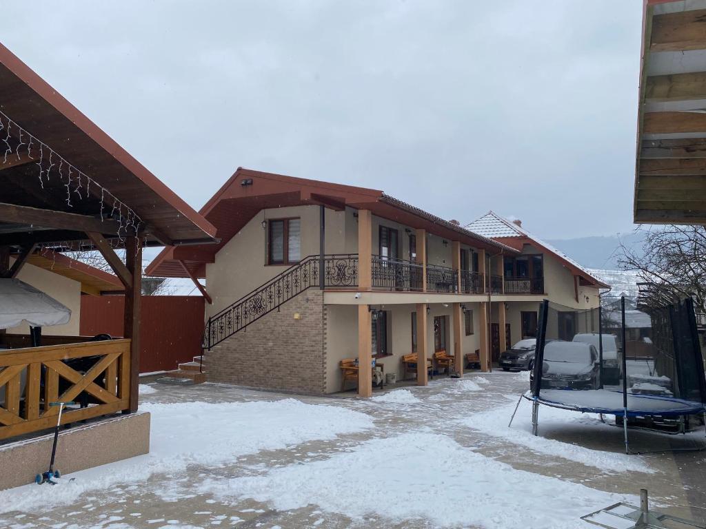 a house with a balcony in the snow at Садиба У Дохтора Відпочинок у Карпатах in Golubinoye