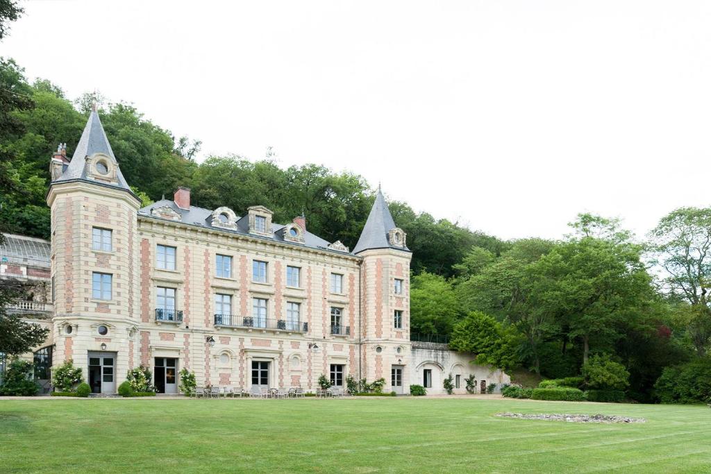 een oud kasteel met een grasveld ervoor bij Château de Perreux, The Originals Collection in Amboise