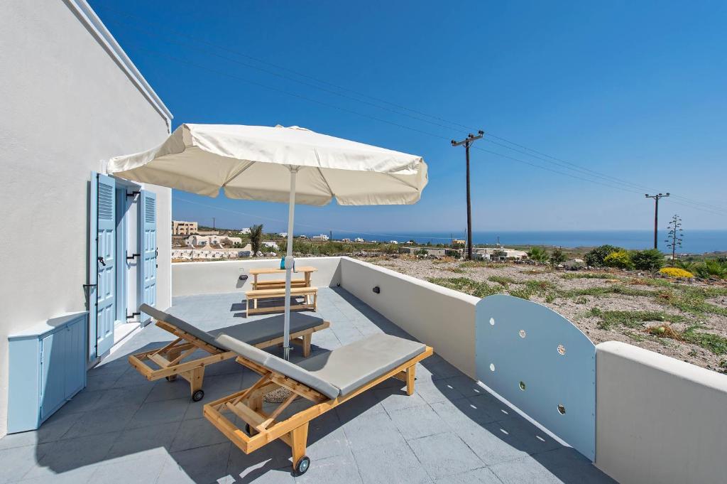 a patio with a table and an umbrella at Ann-Margo House in Fira