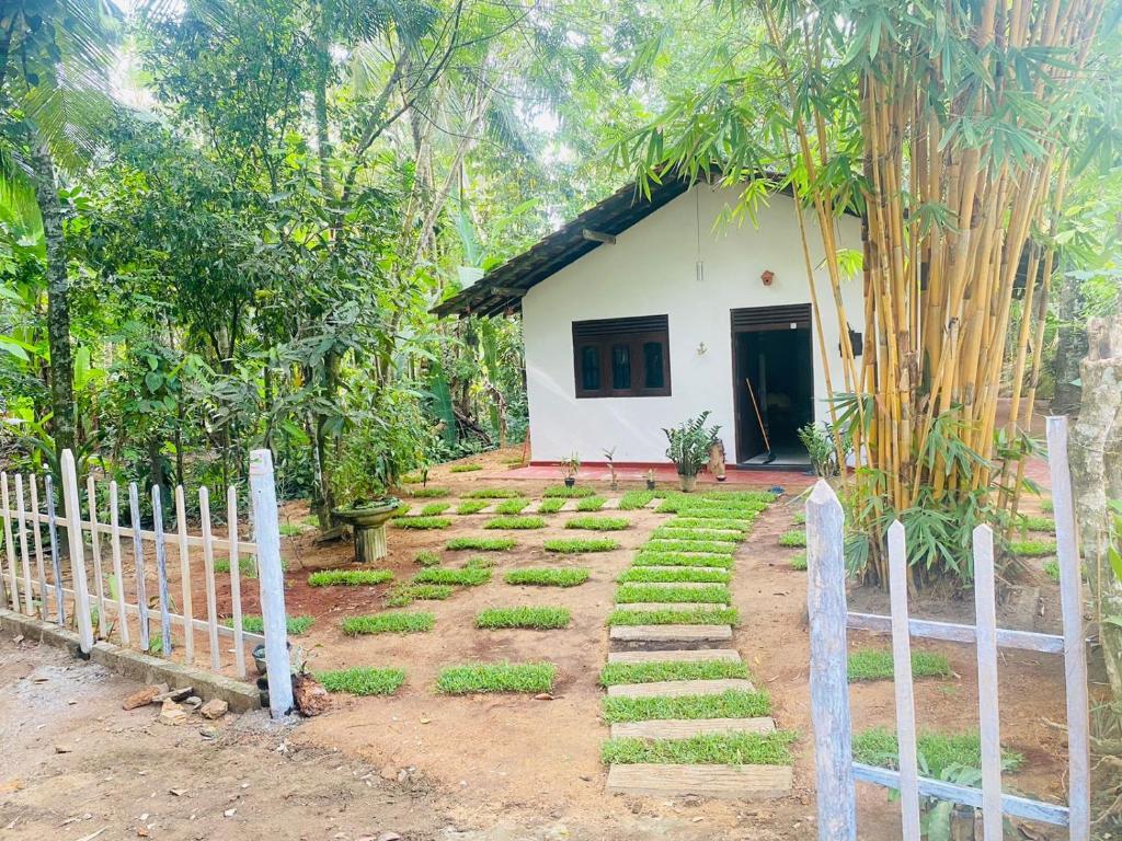 ein Haus mit einem Zaun vor einem Garten in der Unterkunft NEWCINNAMONVILLA in Habaraduwa Central