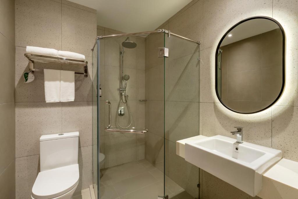 a bathroom with a shower and a sink and a mirror at Lyf Chinatown Kuala Lumpur in Kuala Lumpur