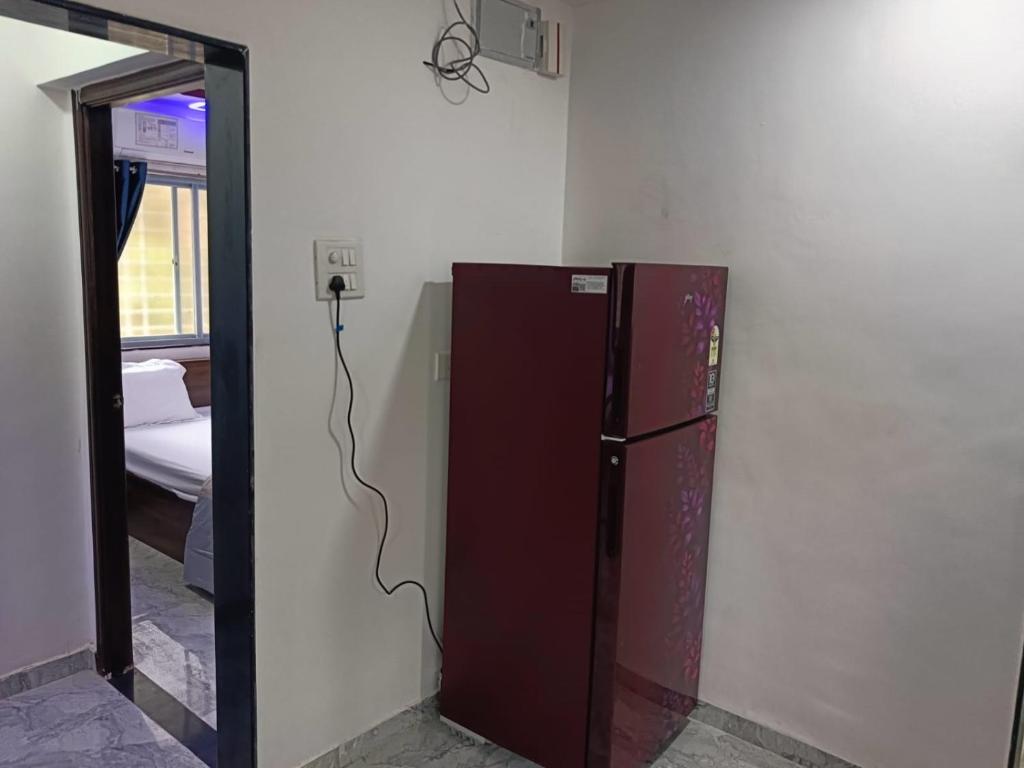 a brown refrigerator in a room with a mirror at Soumil 102 in Chinchwad
