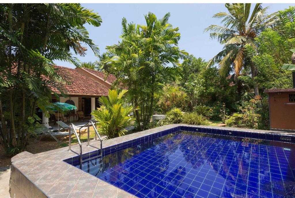 a swimming pool in a yard with a house at Bliss Villa Bentota in Aluthgama