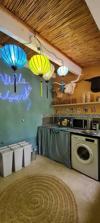 a kitchen with umbrellas hanging on the wall at Villa Aigarden maison d'hôtes in Avignon