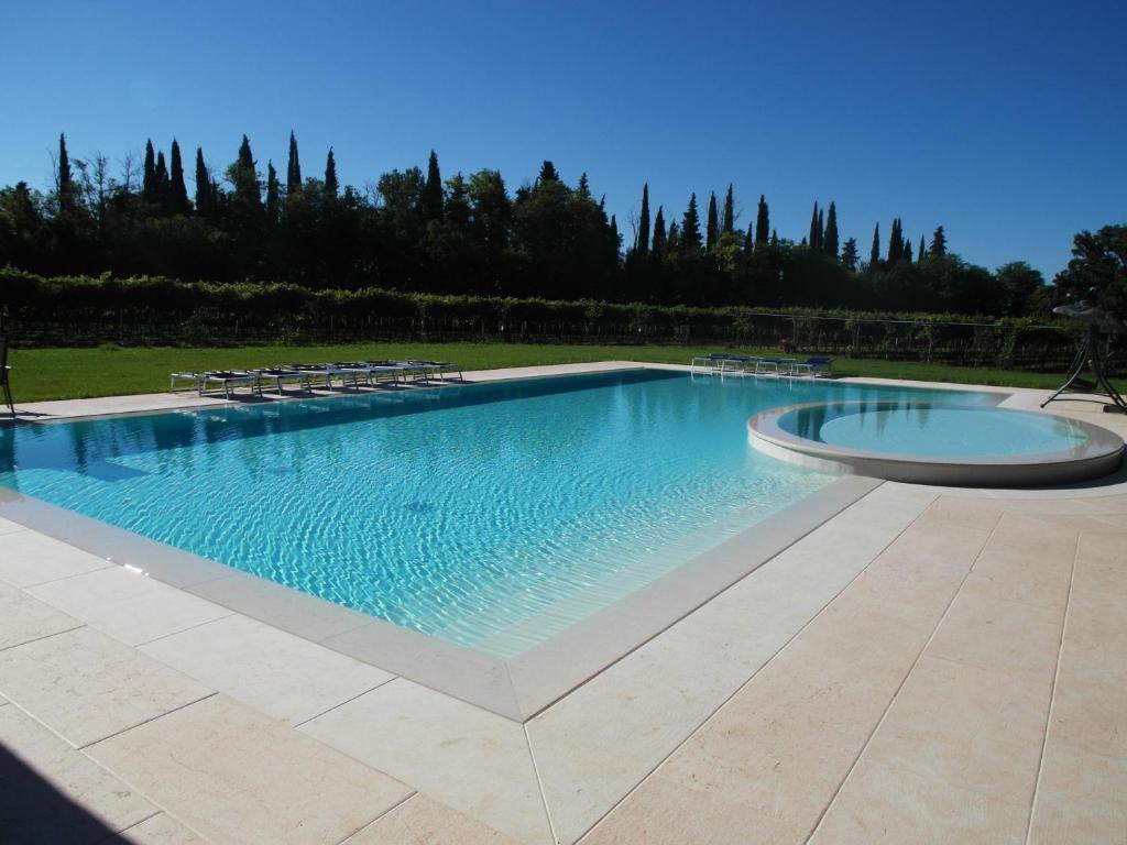 - une grande piscine avec des chaises dans la cour dans l'établissement Relais Villa Selle, à Fumane