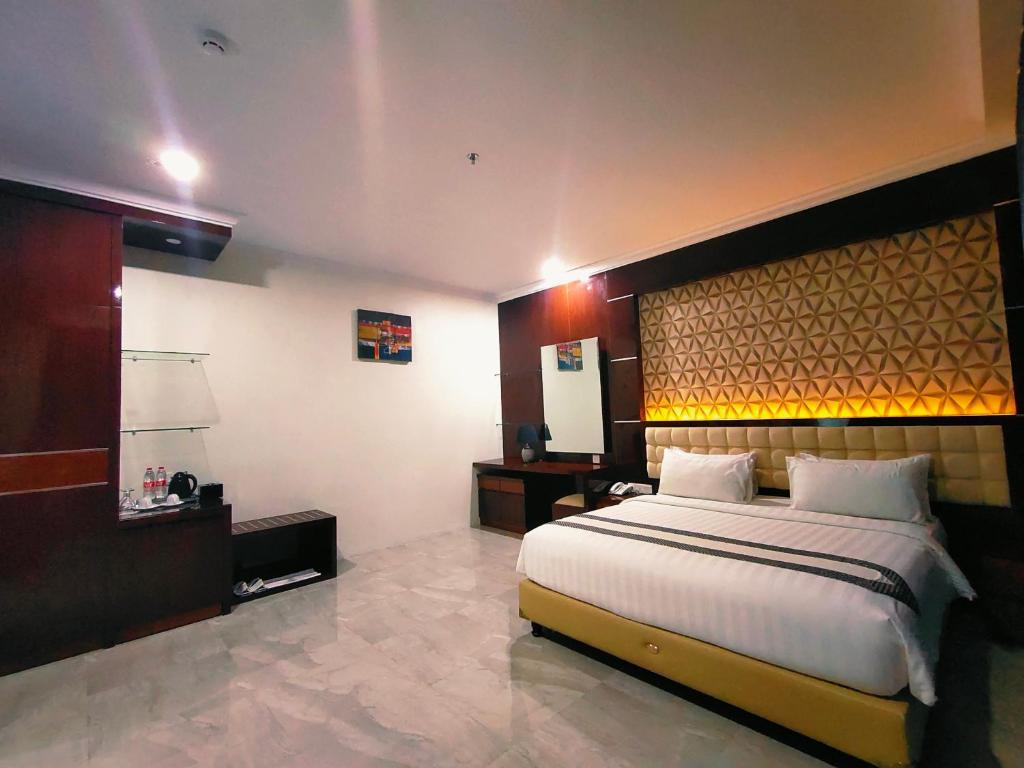 um quarto com uma cama grande num quarto de hotel em Sindoro Hotel Cilacap By Conary em Cilacap