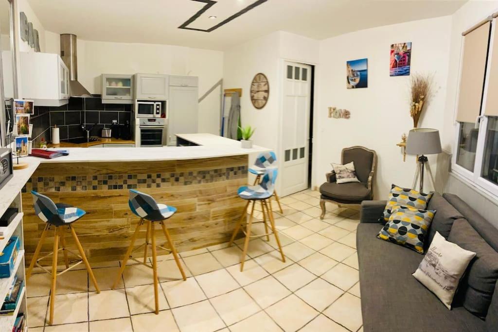a kitchen and a living room with a counter and chairs at Appartement Collioure centre & GARAGE PRIVATIF in Collioure