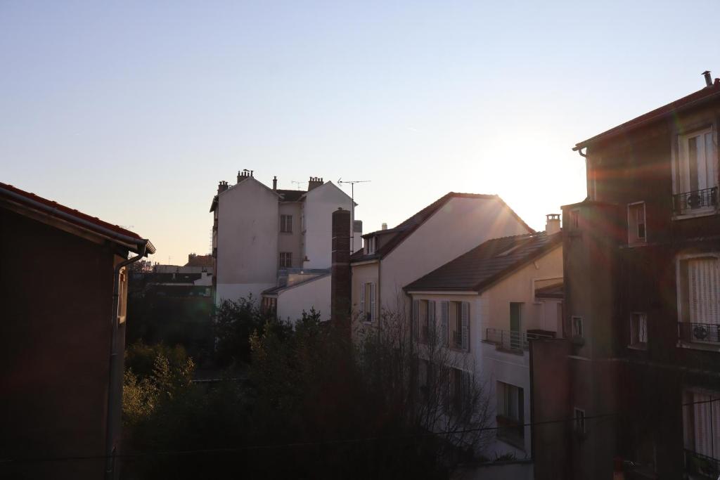 um grupo de edifícios em uma cidade ao pôr do sol em Maison Luxe avec Jardin, 5 Chambres, Home Cinéma - Métro 1 em Vincennes