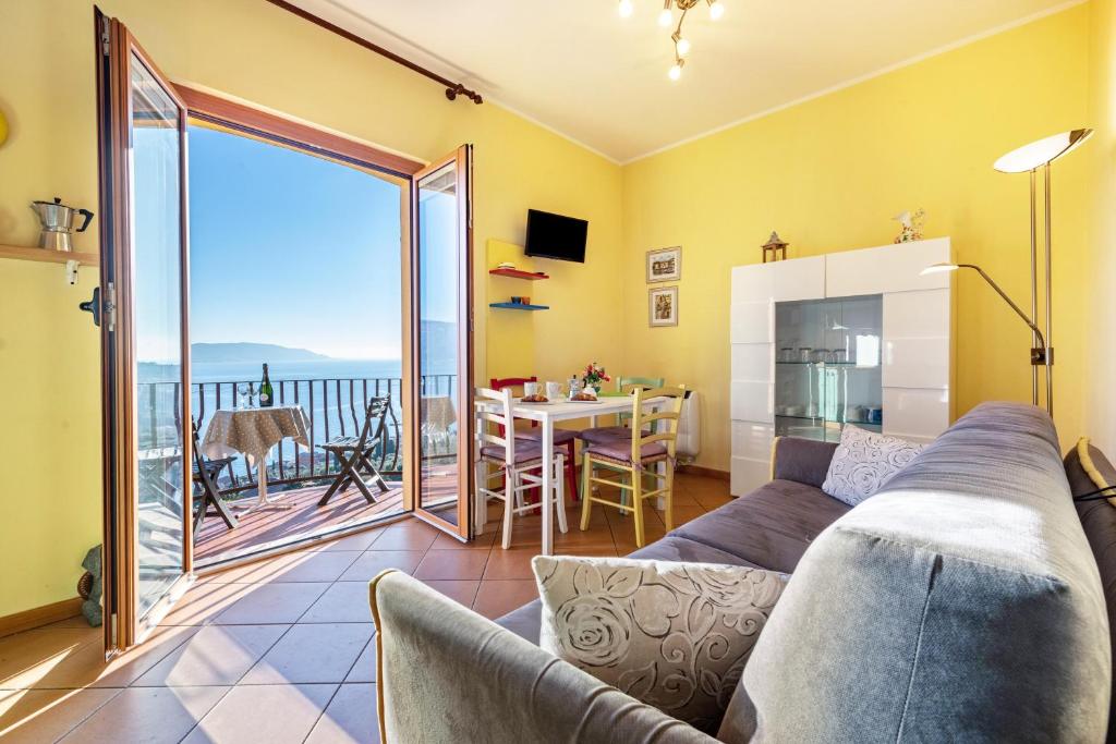 uma sala de estar com um sofá e vista para o oceano em Appartamento Arlecchino em Gargnano
