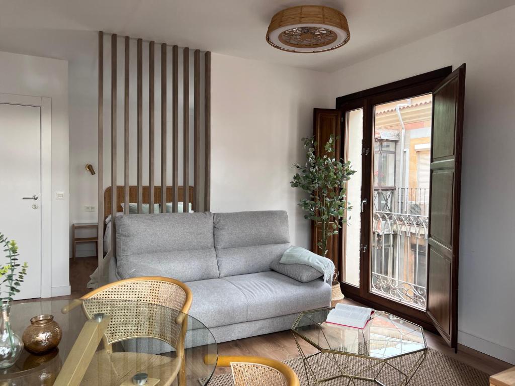 sala de estar con sofá y mesa de cristal en Numancia Suites, en Soria