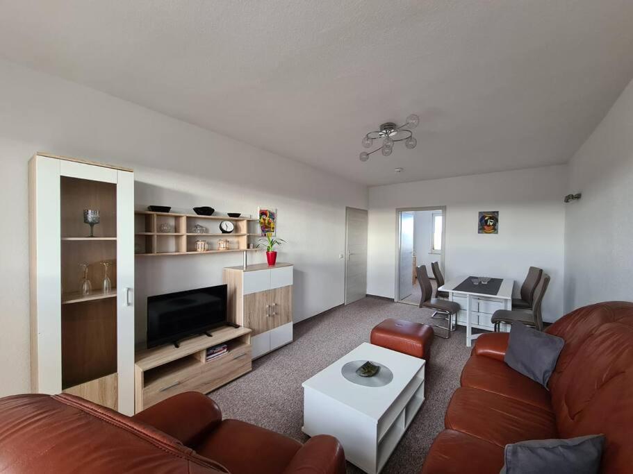 uma sala de estar com um sofá e uma mesa em Gästewohnung KL. WZL 30_5 