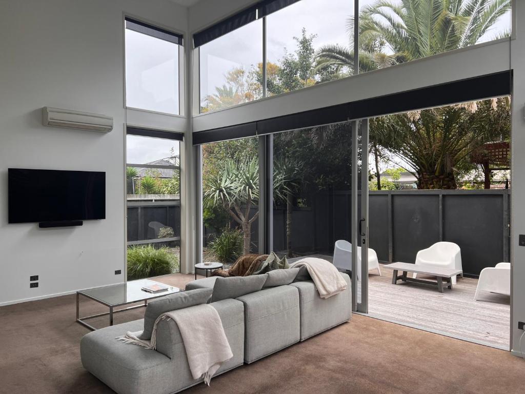 a living room with a couch and a tv at Modern Home Central Mount in Mount Maunganui