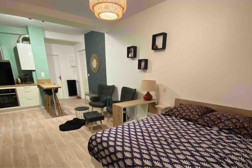 - une chambre avec un lit, une table et des chaises dans l'établissement Charmant studio idéalement placé et paisible !, à Oloron-Sainte-Marie