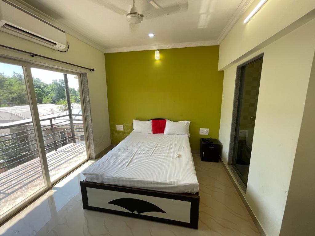um quarto com uma cama num quarto com uma janela em Hotel kumar em Panchgani