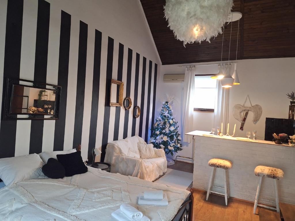 - un salon avec un arbre de Noël et un lit dans l'établissement Apartman Sissi, à Pančevo