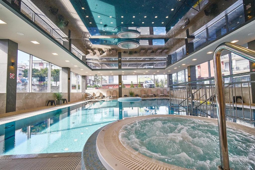 una grande piscina con vasca idromassaggio in un edificio di SZAFIROWE APARTAMENTY 3 kryty basen i sauna RESORT KLIFOWA a Rewal