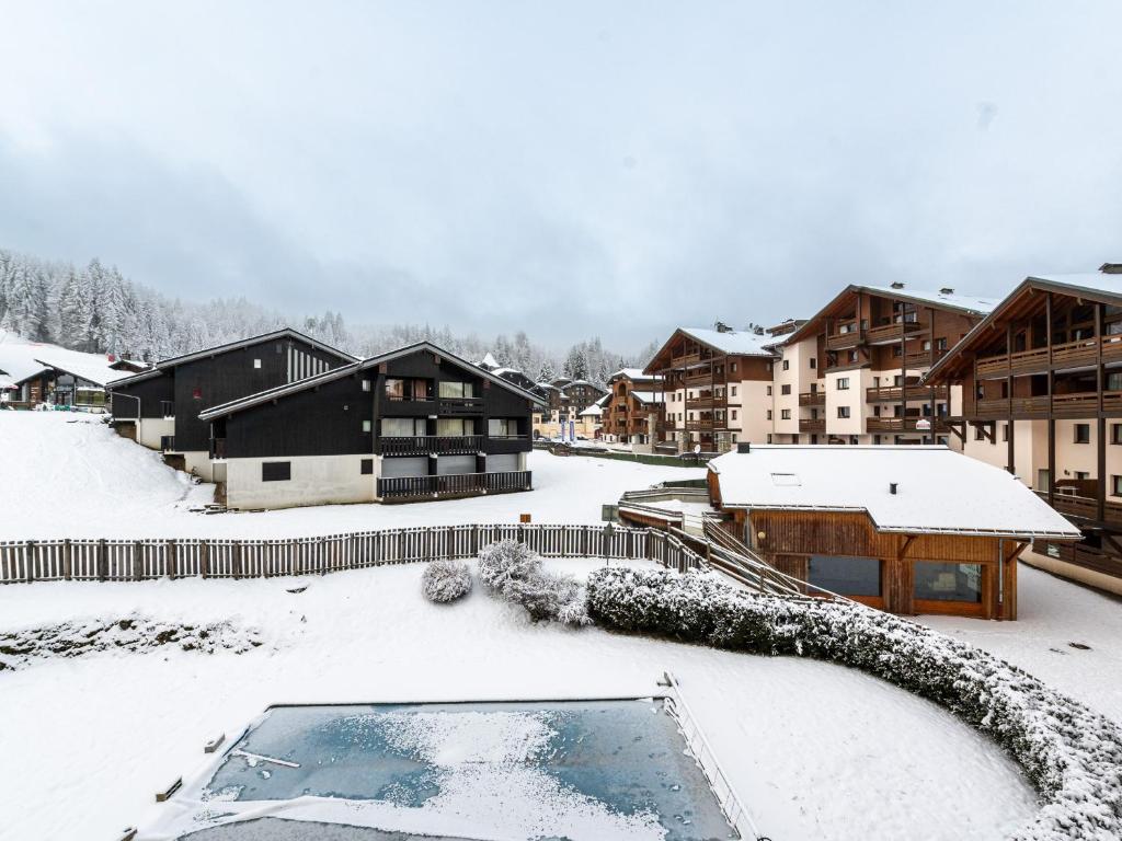 een door sneeuw bedekte tuin met huizen en gebouwen bij Les Eterlous 25 - Appt vue pistes 4 pers in Morillon